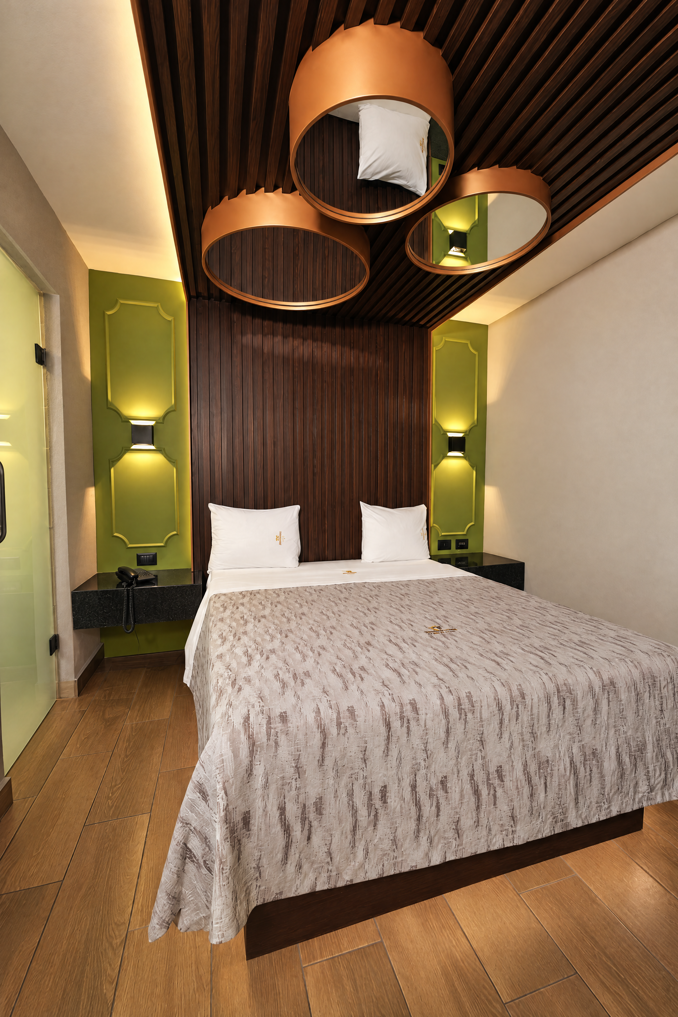 Habitación de Mediterráneo con cama, acentos verdes y luminarias circulares
