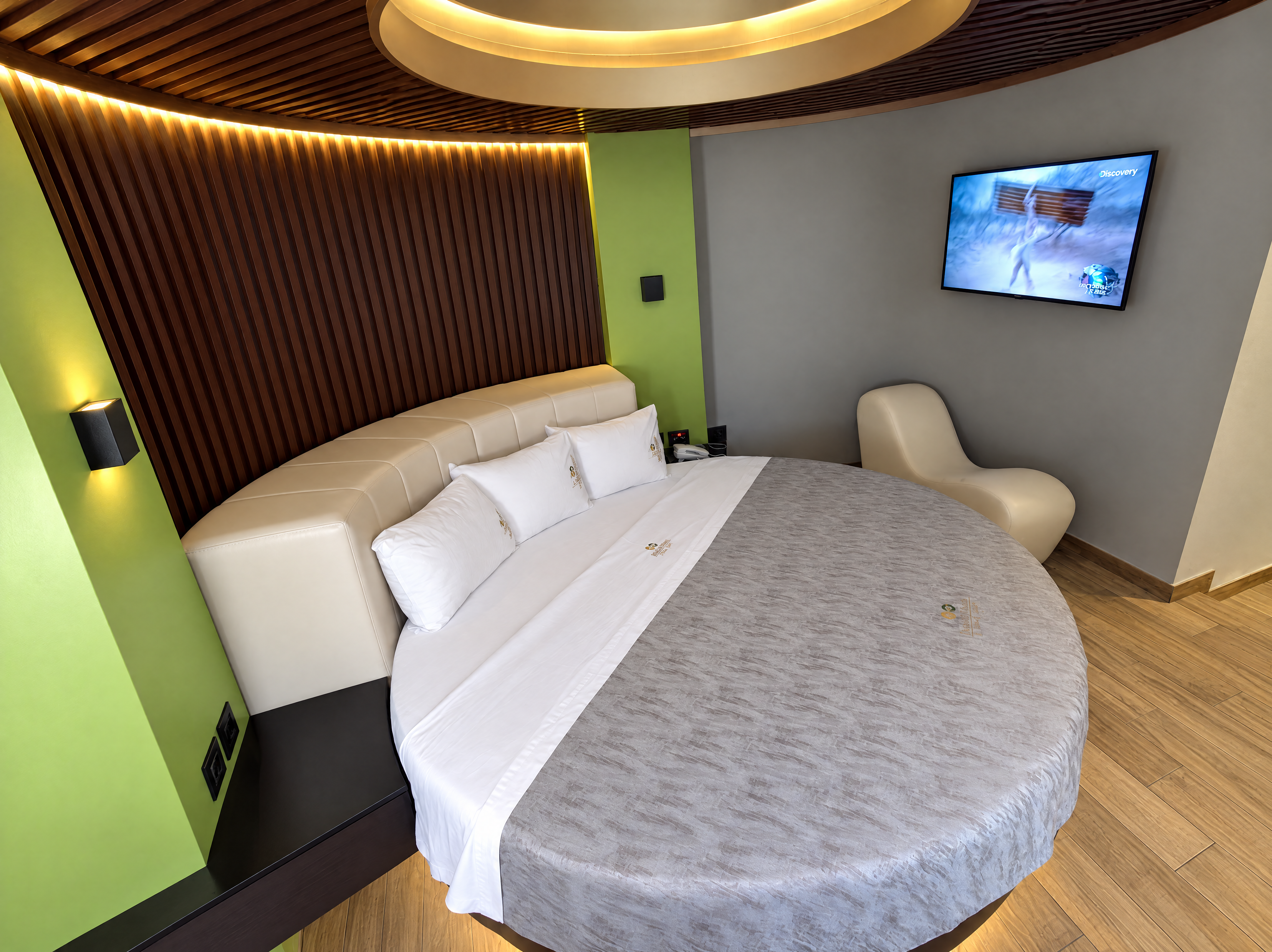 Habitación de Mediterráneo con cama redonda, cabecera curva y televisión