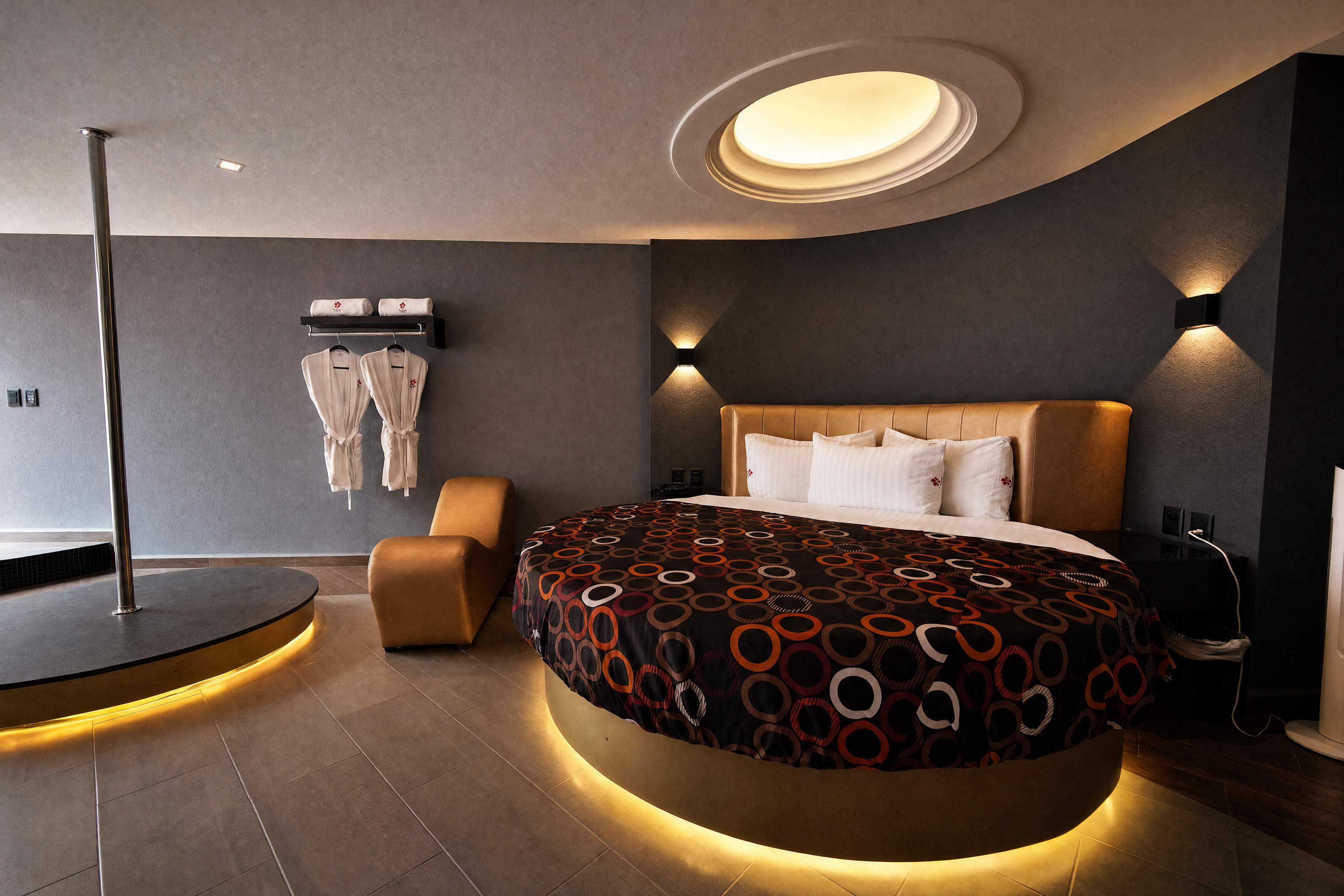 Habitación de Motel Speed con cama redonda e iluminación cálida bajo la base