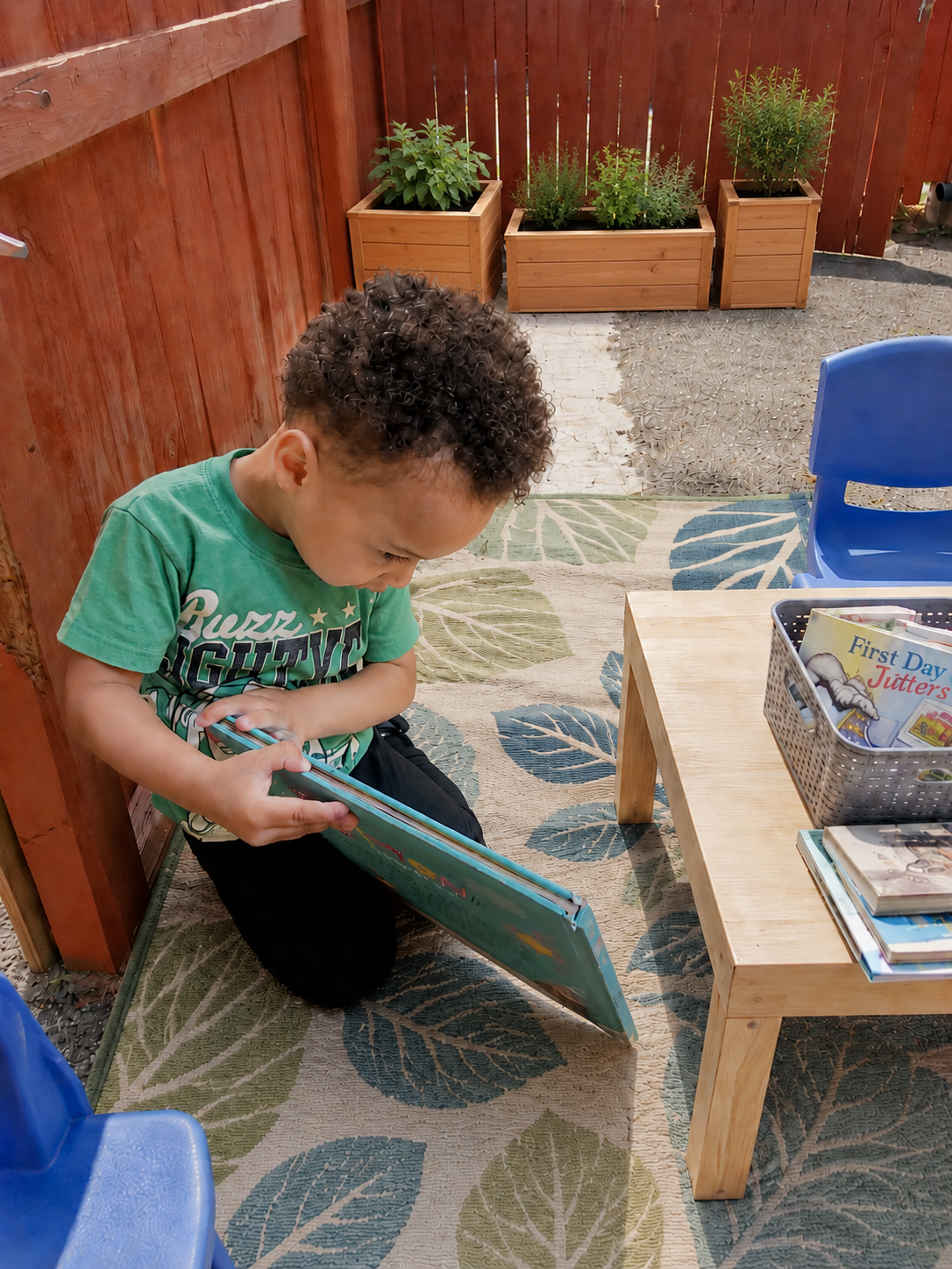 Child reading outside in an outdoor classroom at Blossom Grove Academy