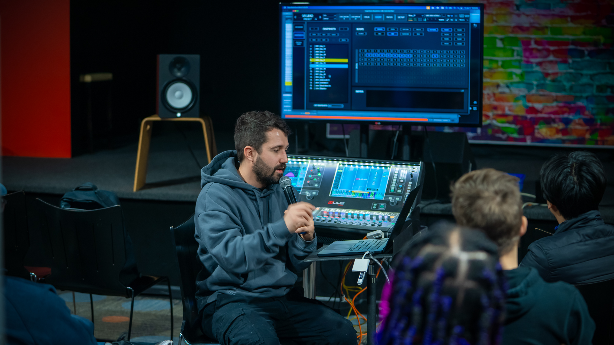 A production professional teaching at an audio console