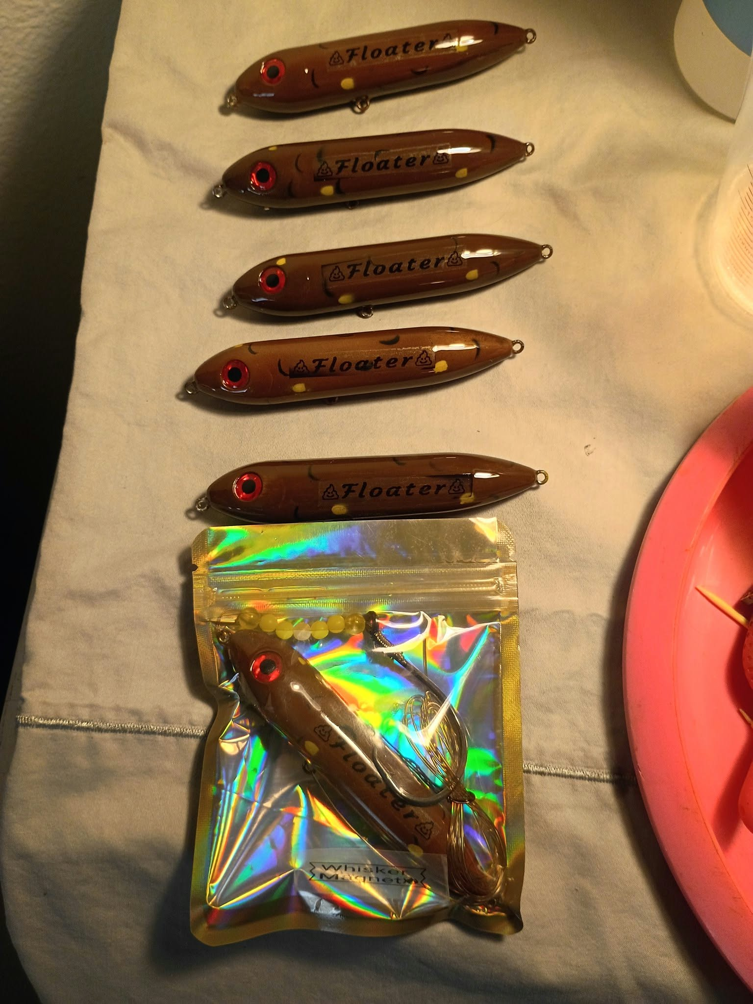 Daniel's brown hand-painted Floater lures, with one packaged lure below