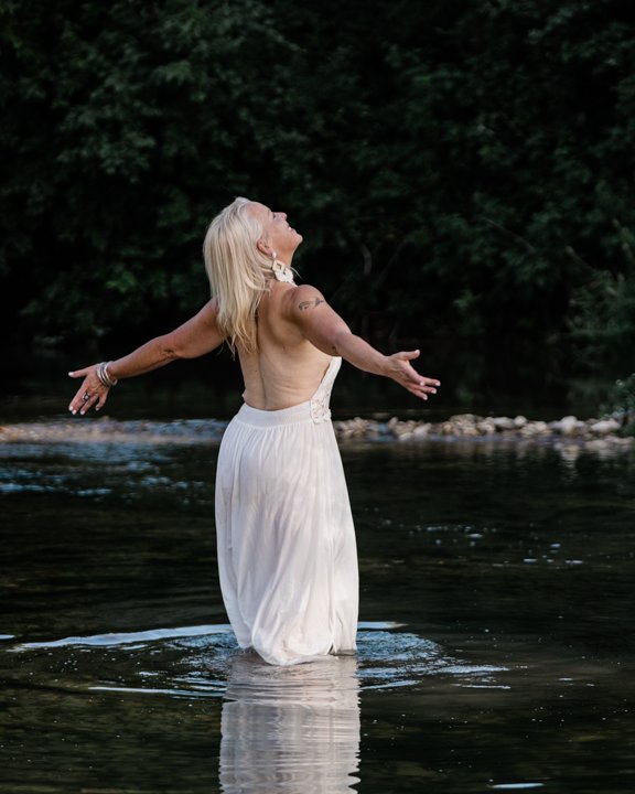 Laurie in the river, arms open