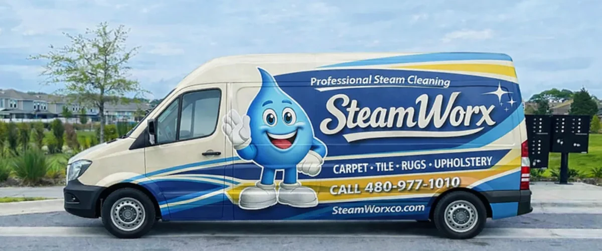 A Sprinter van, branded with the SteamWorx logo and contact information, parked outside a building.