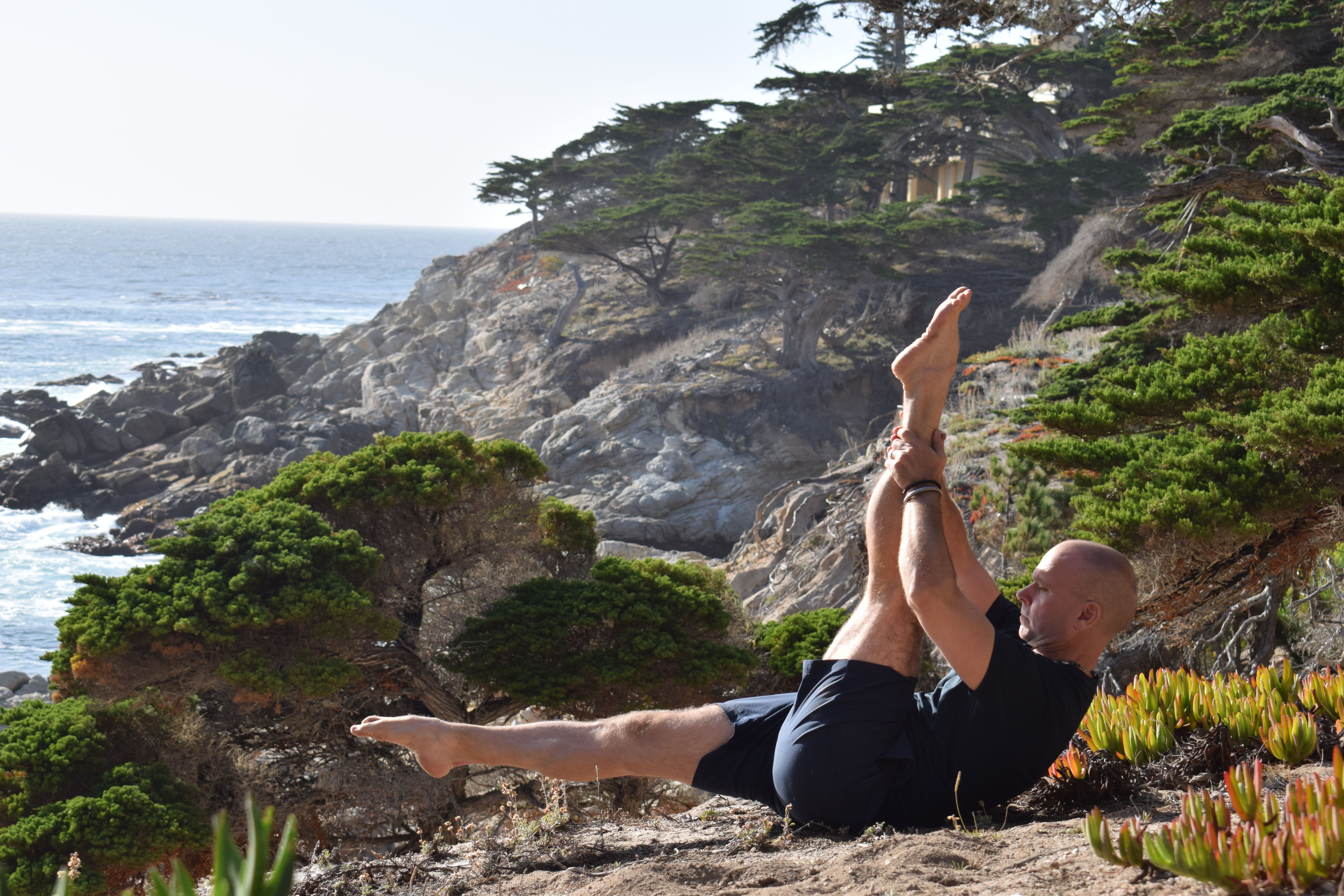 Joakim practising Pilates on a coastal cliff