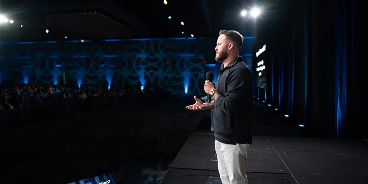 Justin Brock speaking on stage