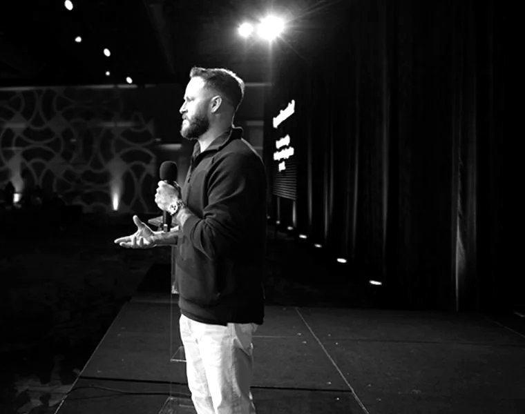 Justin Brock speaking on stage