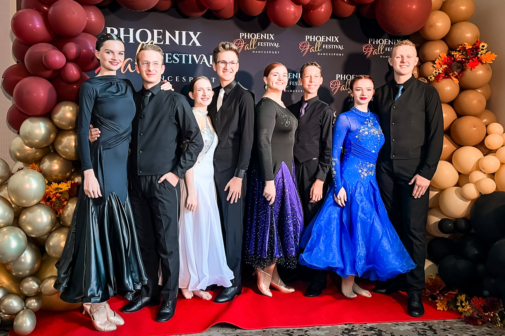 Youth ballroom dancers posing at a ballroom event.
