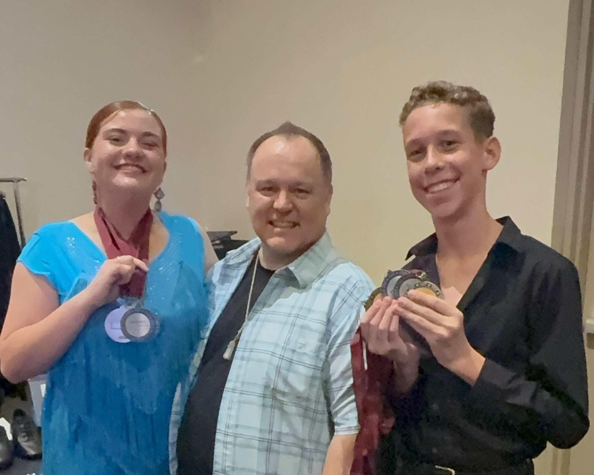 Ross Pearce with two Phoenix Ballroom Academy students after a ballroom competition