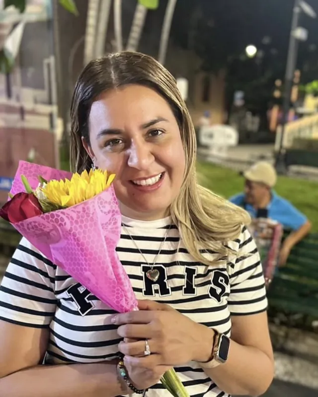 Alma Sández en una etapa anterior de su vida, sonriendo con un ramo de flores