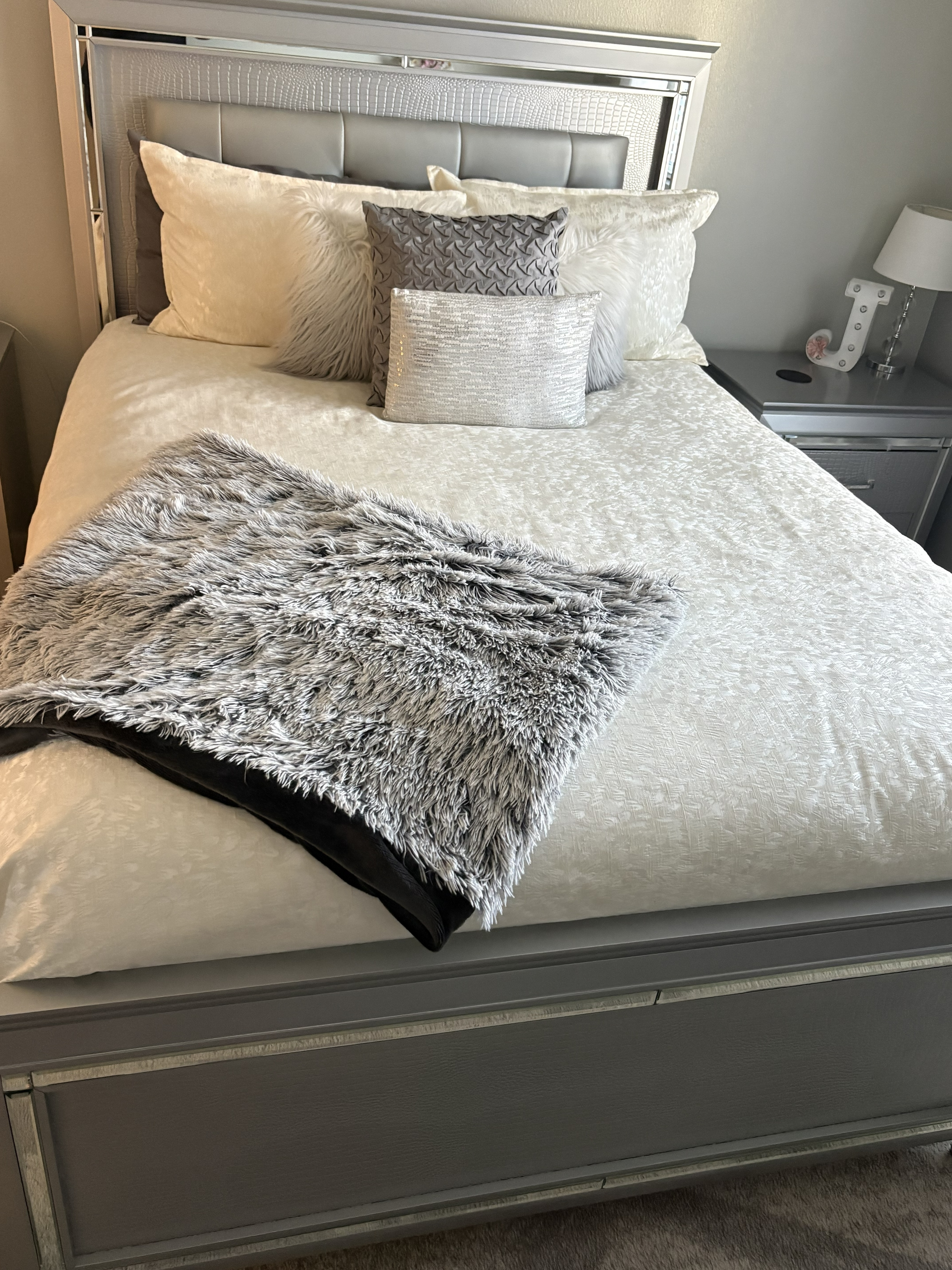 Hotel-folded towels and a welcome card on a freshly made guest bed