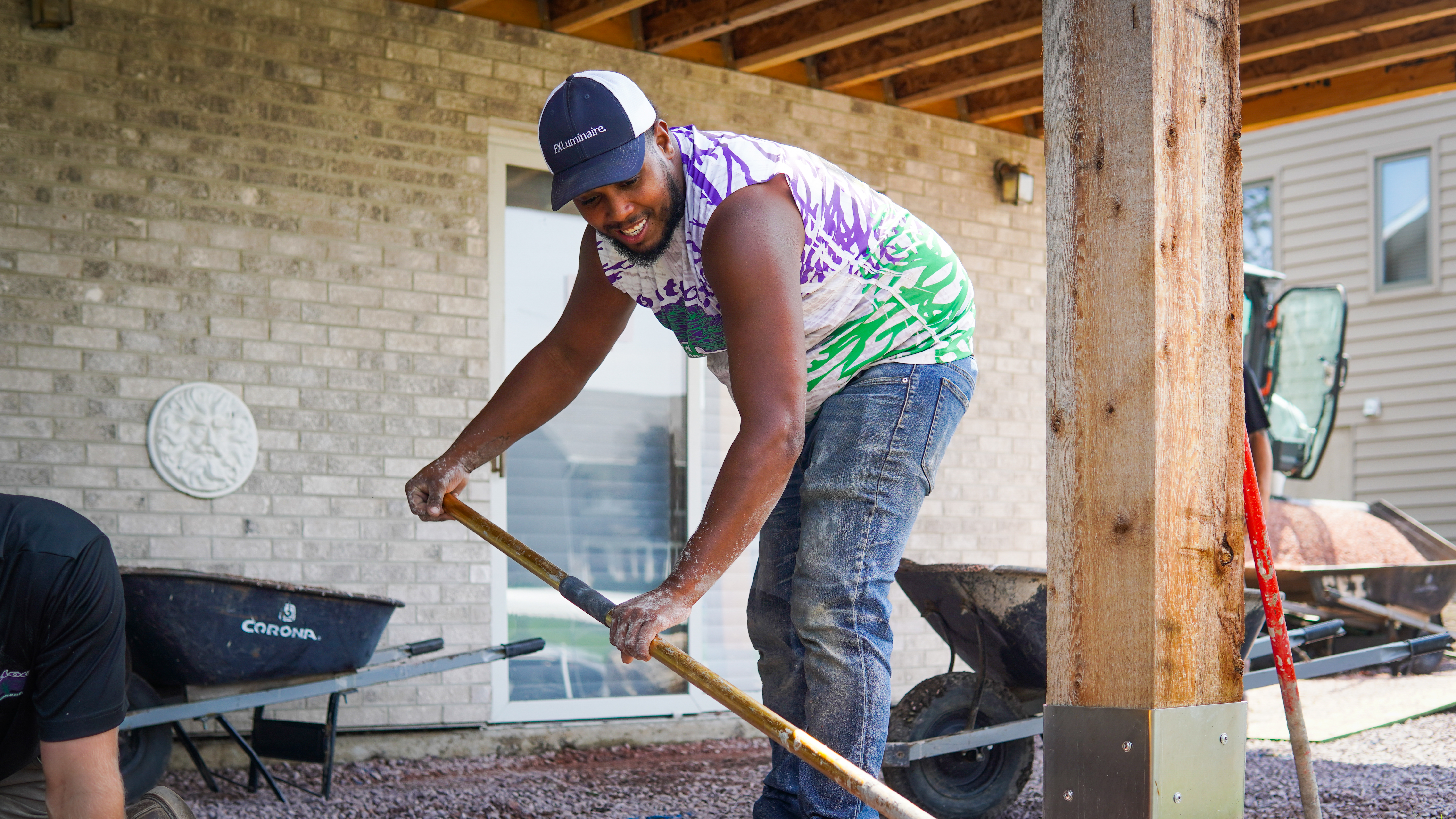 Crew member working a wooden post on site