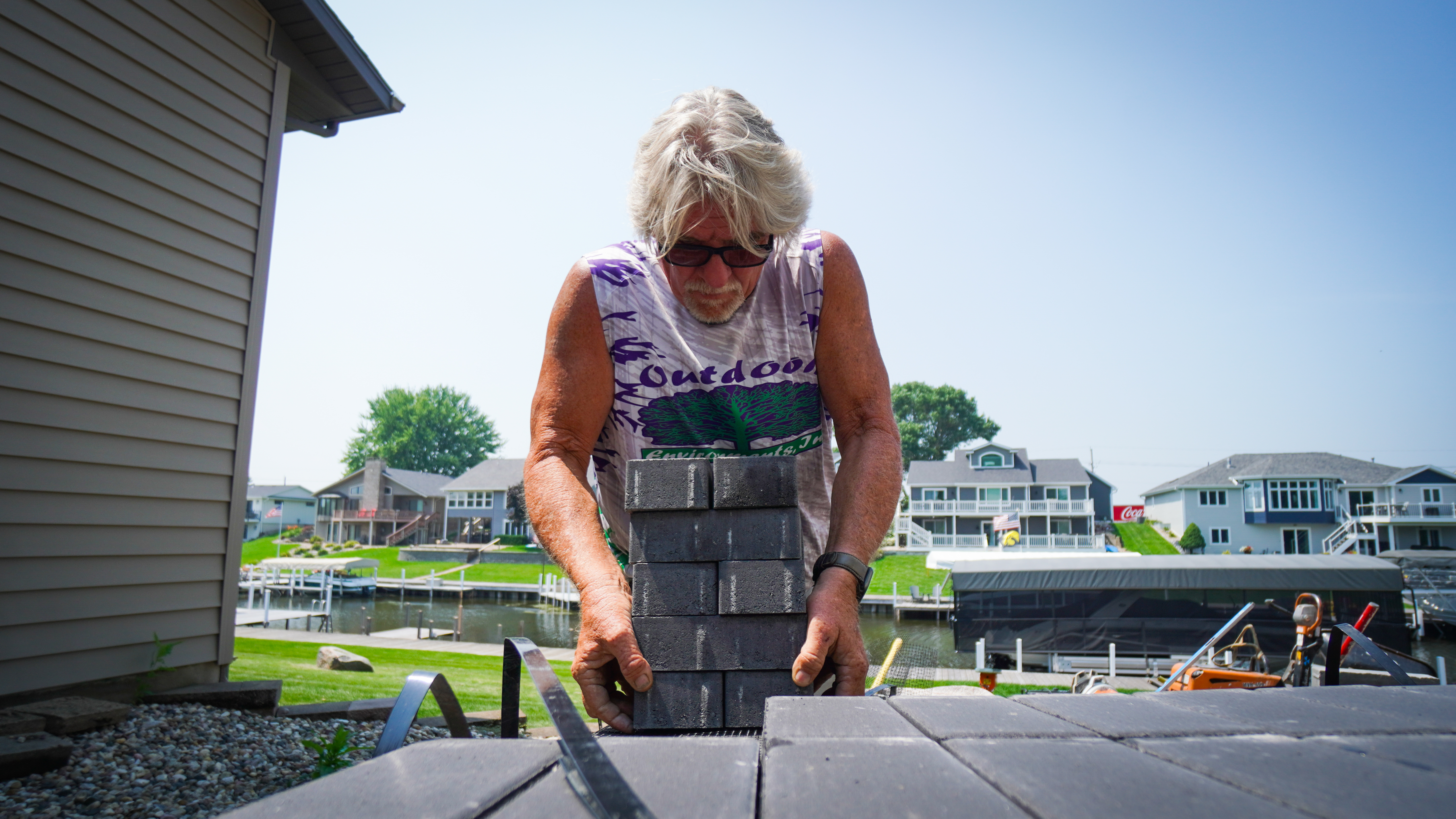 Crew member carrying stacked paver blocks