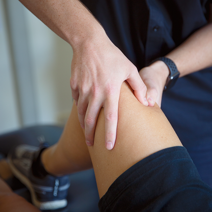 Physiotherapist treating client with knee pain