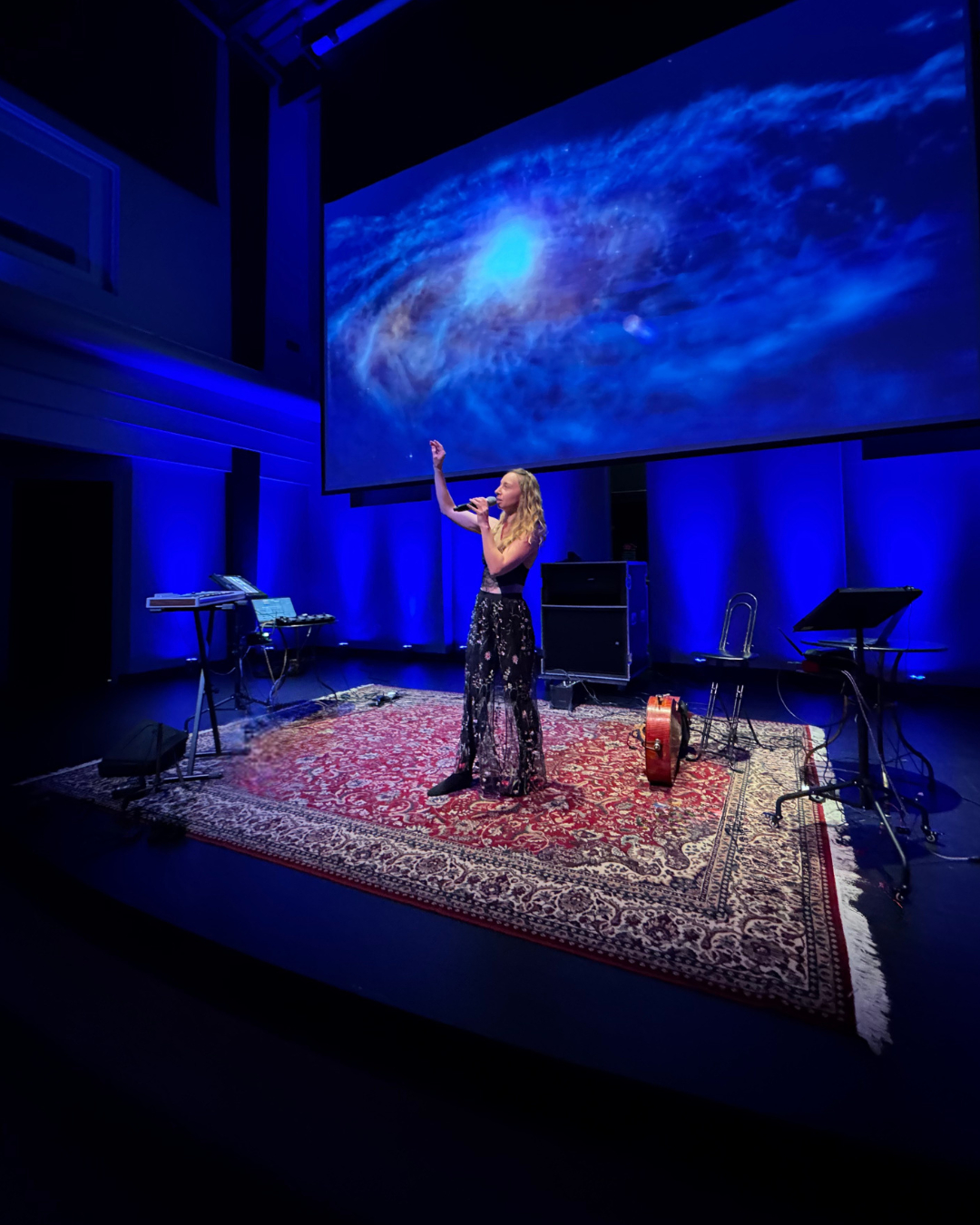 Særa Fiøra performing beneath a galaxy projection