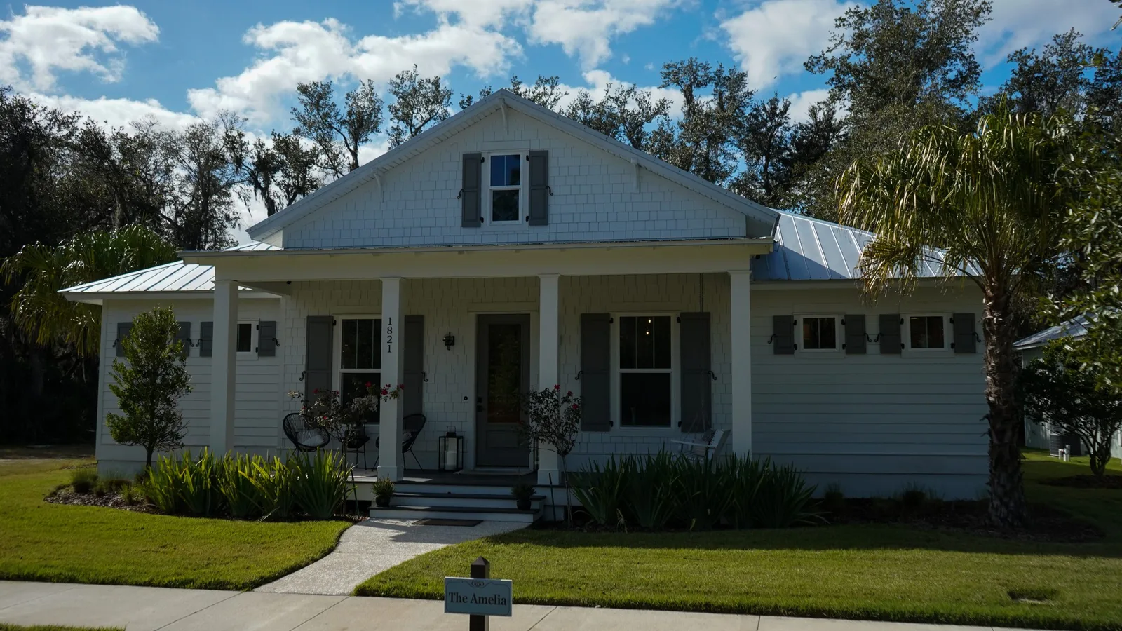 White craftsman cottage with a freshly painted front porch and dark shutters
