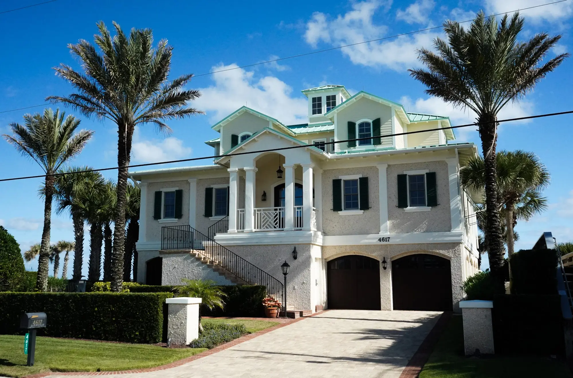 Coastal Florida estate with fresh exterior paint, white columns and green shutters