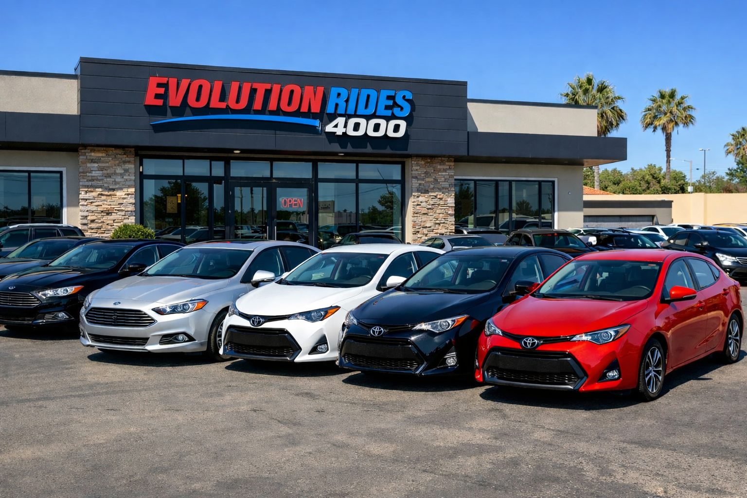 Parking lot in front of Evolution Rides 4000 store featuring Ford Fusion cars in black and silver and Toyota Corolla vehicles in white, black, blue, and red lined up outside a modern rental office building on a sunny day.