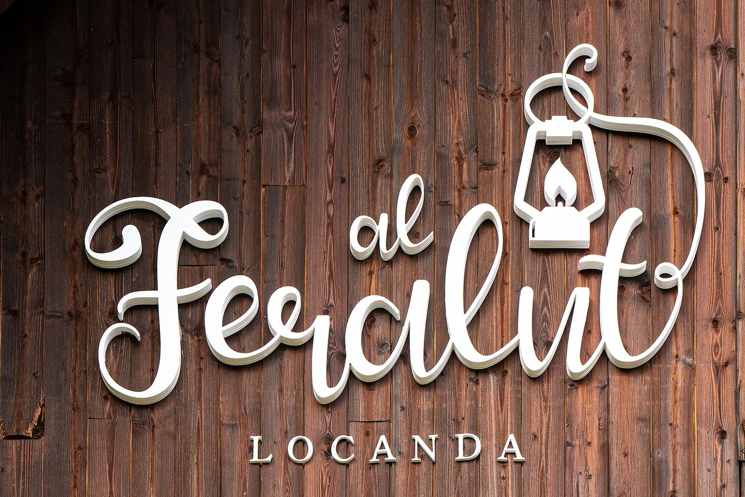 The wooden sign of the Al Feralut inn with its lantern