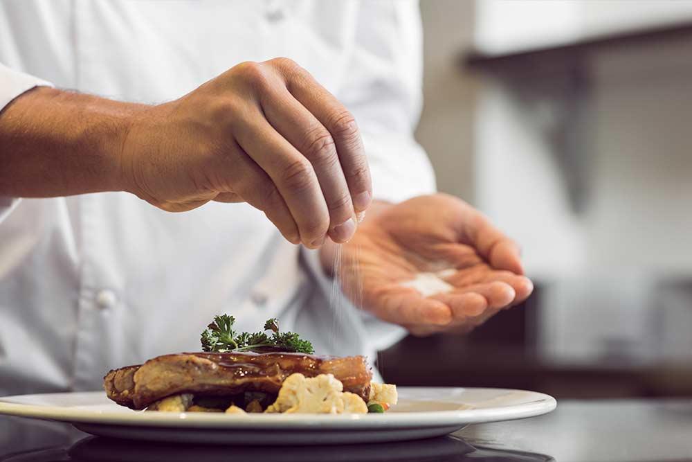 The chef finishing a dish with salt