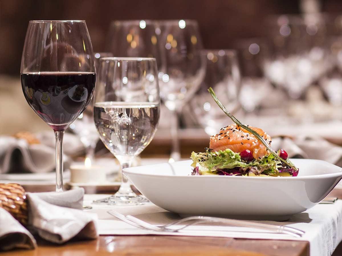 Wijnglazen en een geserveerd gerecht op de gedekte tafel