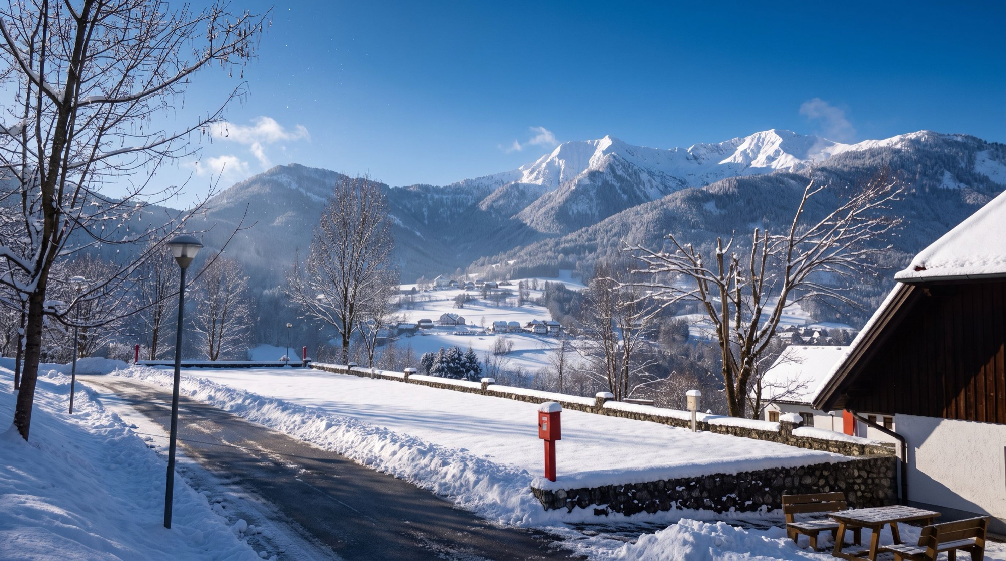 Der Weg im Campingplatz unter frischem Schnee, mit den weißen Bergen in der Sonne
