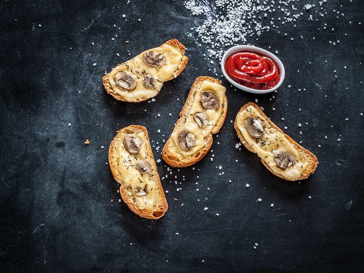 Bruschetta with mushrooms on a dark board