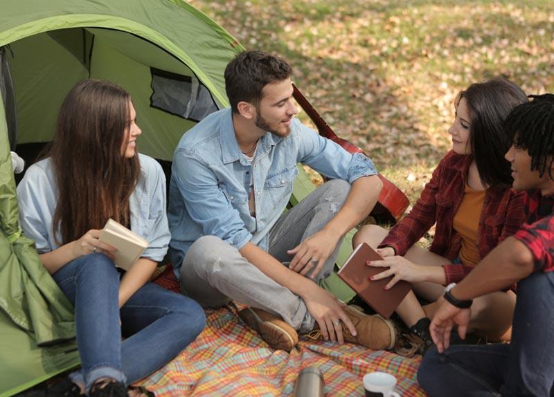Un gruppo di amici seduti davanti alla tenda