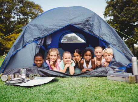 Kinder schauen aus dem Eingang eines Zelts