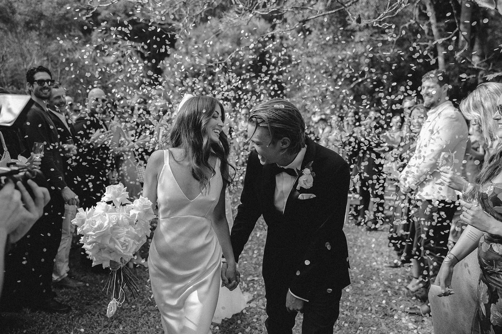 Outdoor ceremony beneath a floral arch