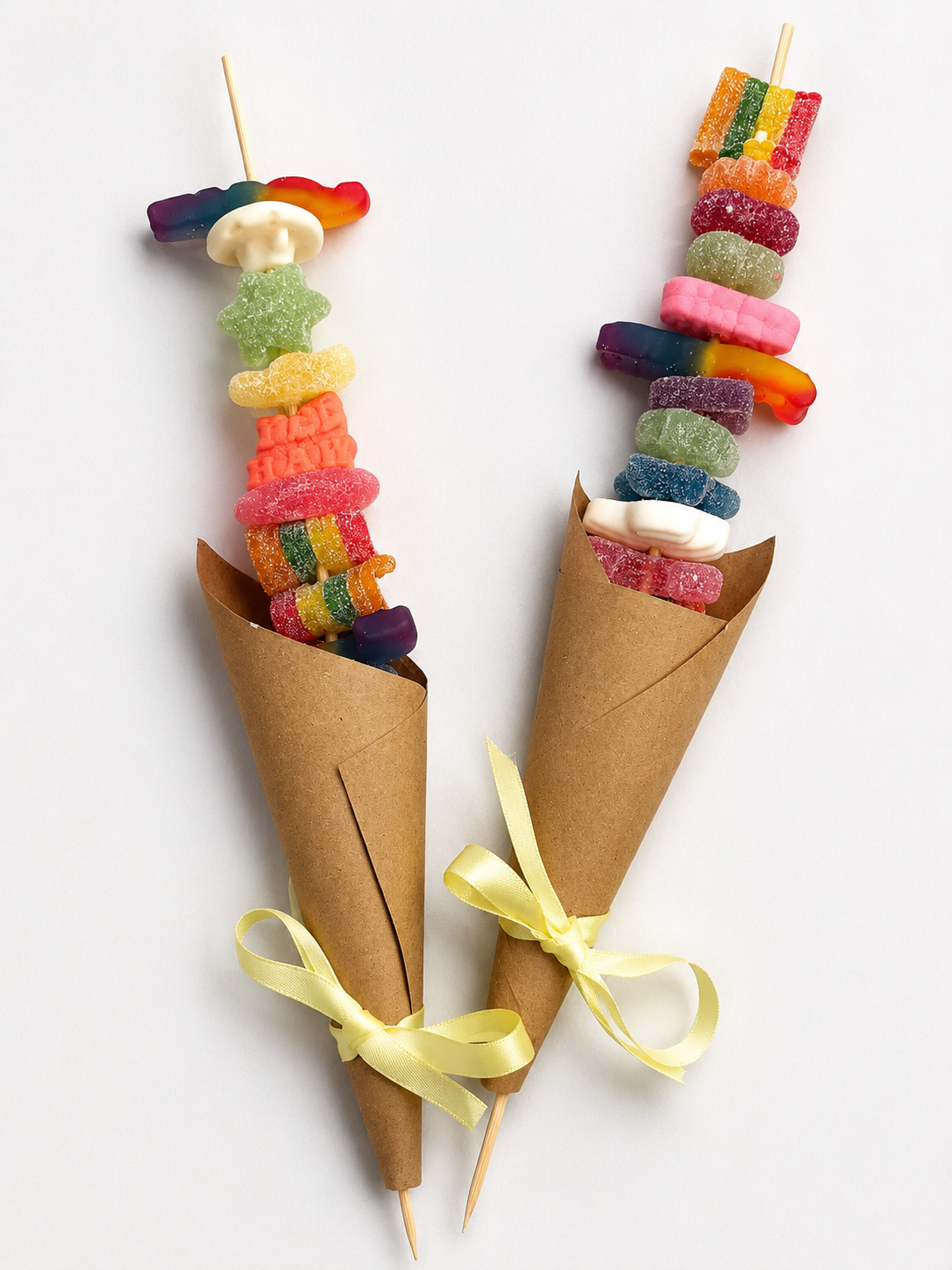 A bundle of handmade rainbow candy skewers from The Sweet Society, tied with ribbon