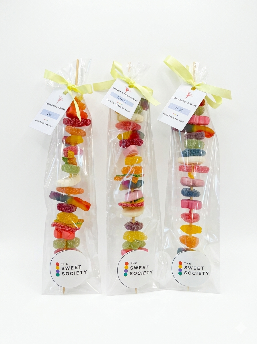 A bundle of handmade rainbow candy skewers from The Sweet Society, tied with ribbon