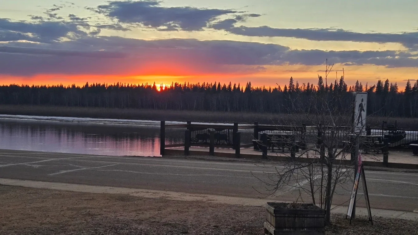 Wooden deck with picnic tables overlooking the Peace River, directly across from The Harvest Table on River Road in Fort Vermilion