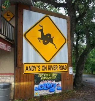 Tubing equipment, rafts, or a shuttle bus near the Frio River access point at Andy's on River Road in Concan, TX.