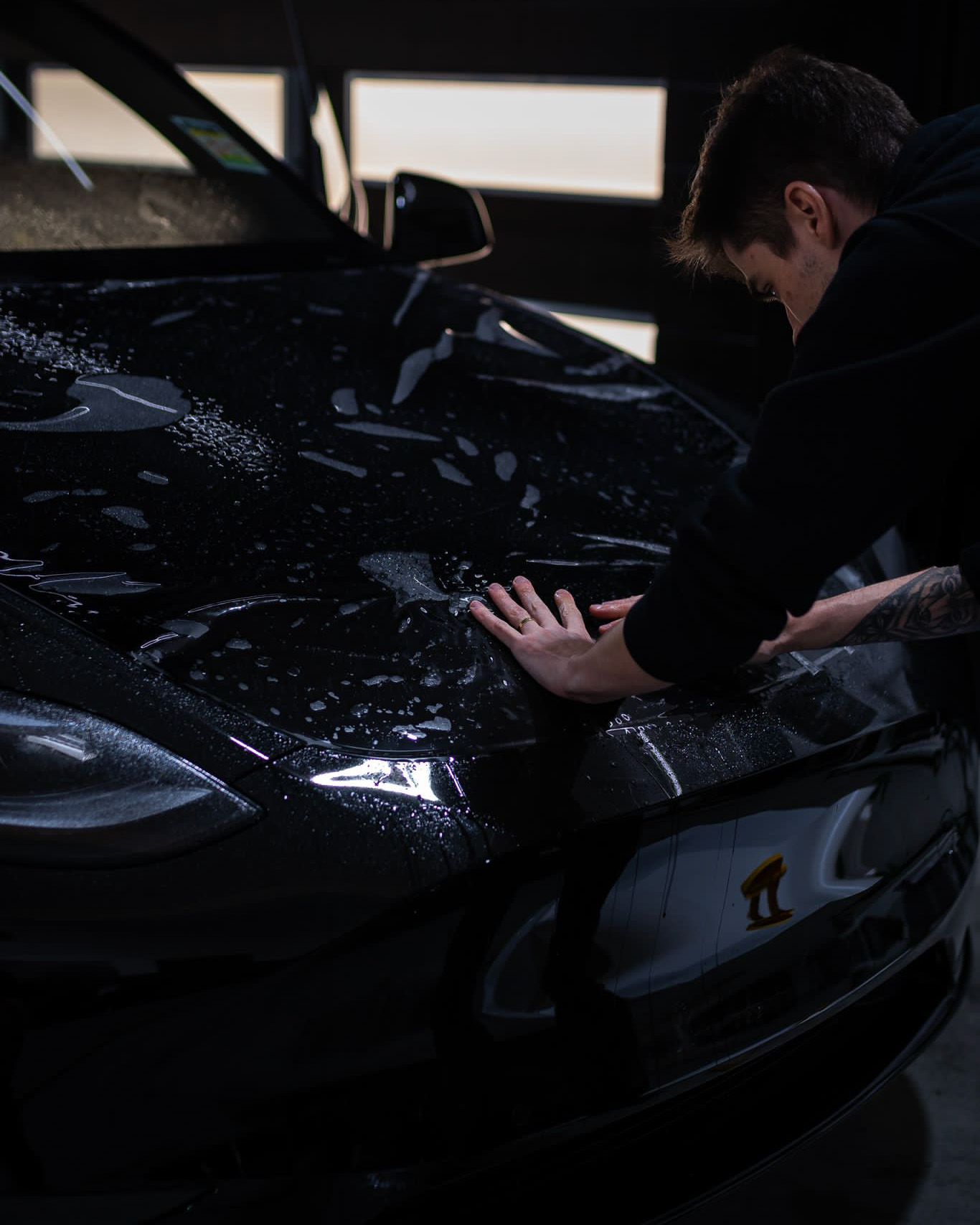 Fernando laying paint protection film across a bonnet