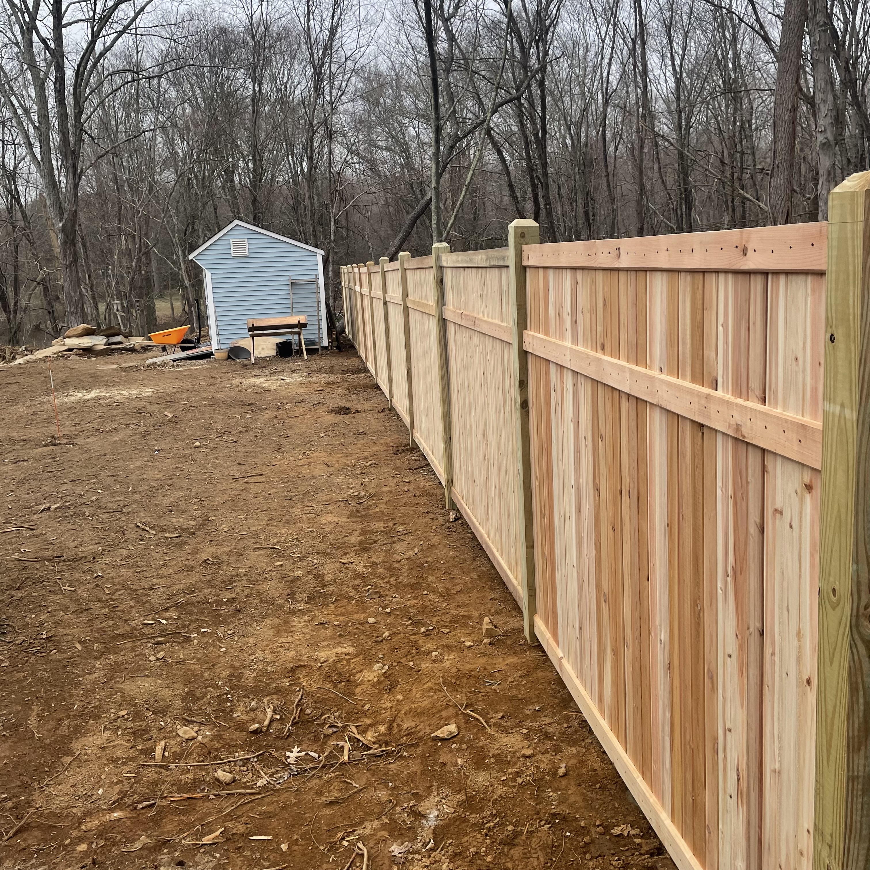 Wooden fence with a shed behind it