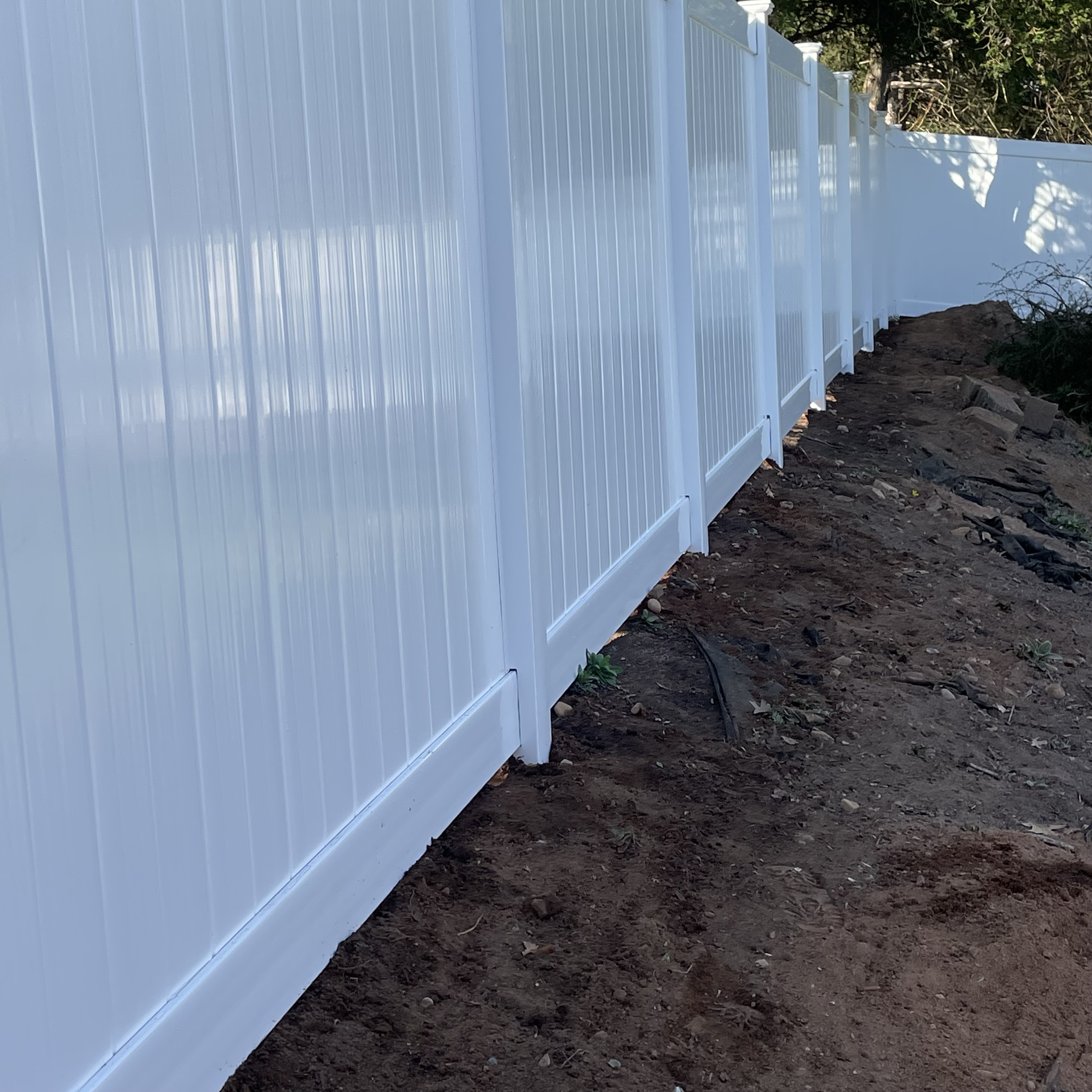 White fence with a dirt path below