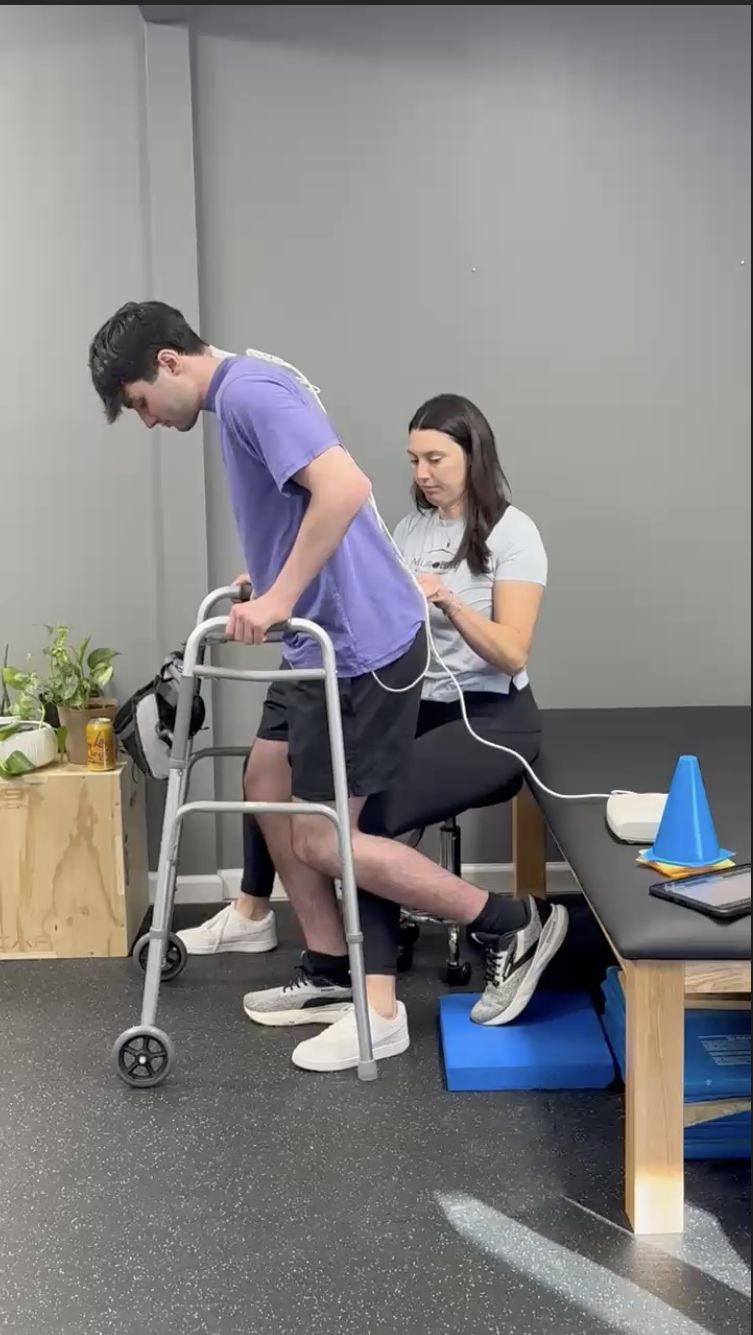 Dr. Lauren Young using ARC-EX spinal cord stimulation during therapy with an individual with spinal cord injury