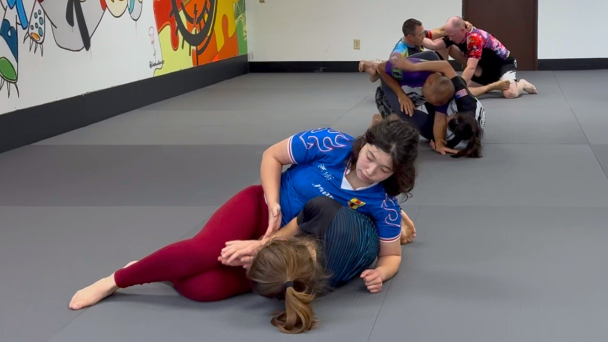 Three pairs of training partners practicing no-gi jiu jitsu on the mats at 608 Jiu Jitsu.