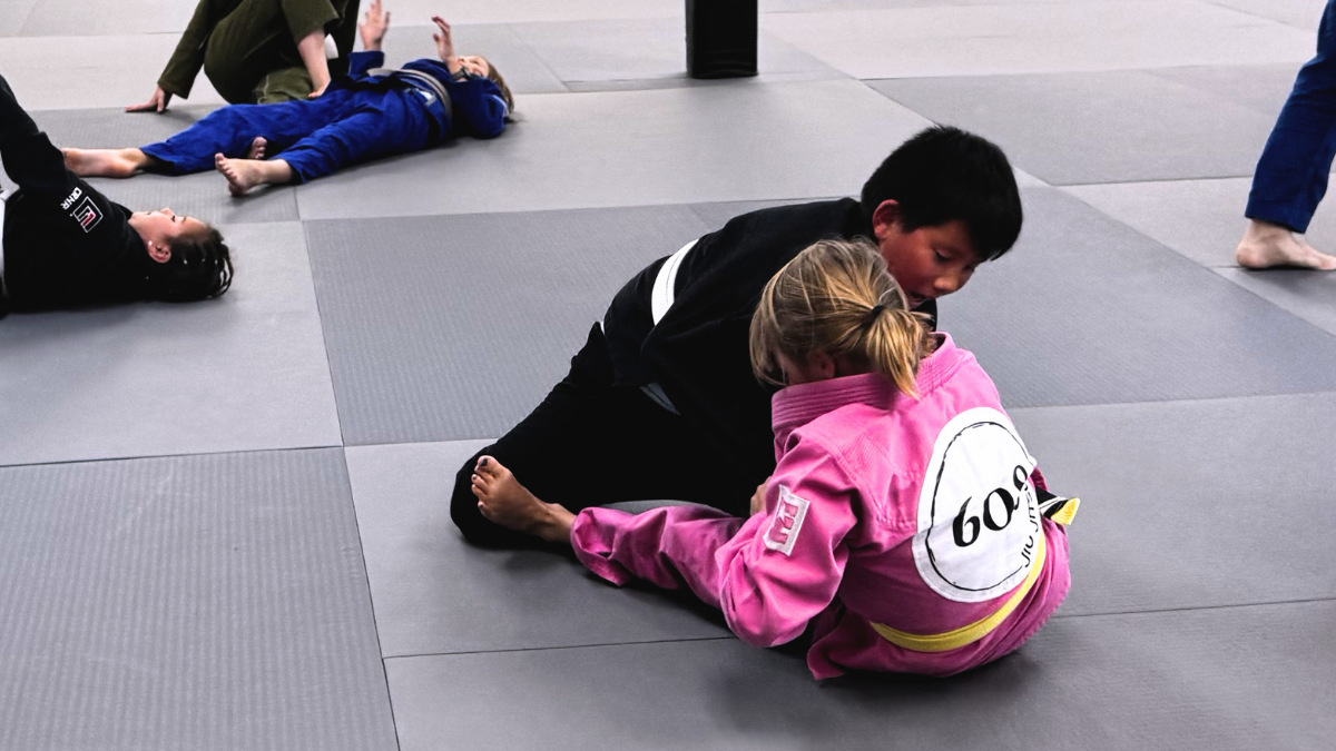 Two Champions students work through a jiu jitsu position during class at 608 Jiu Jitsu.