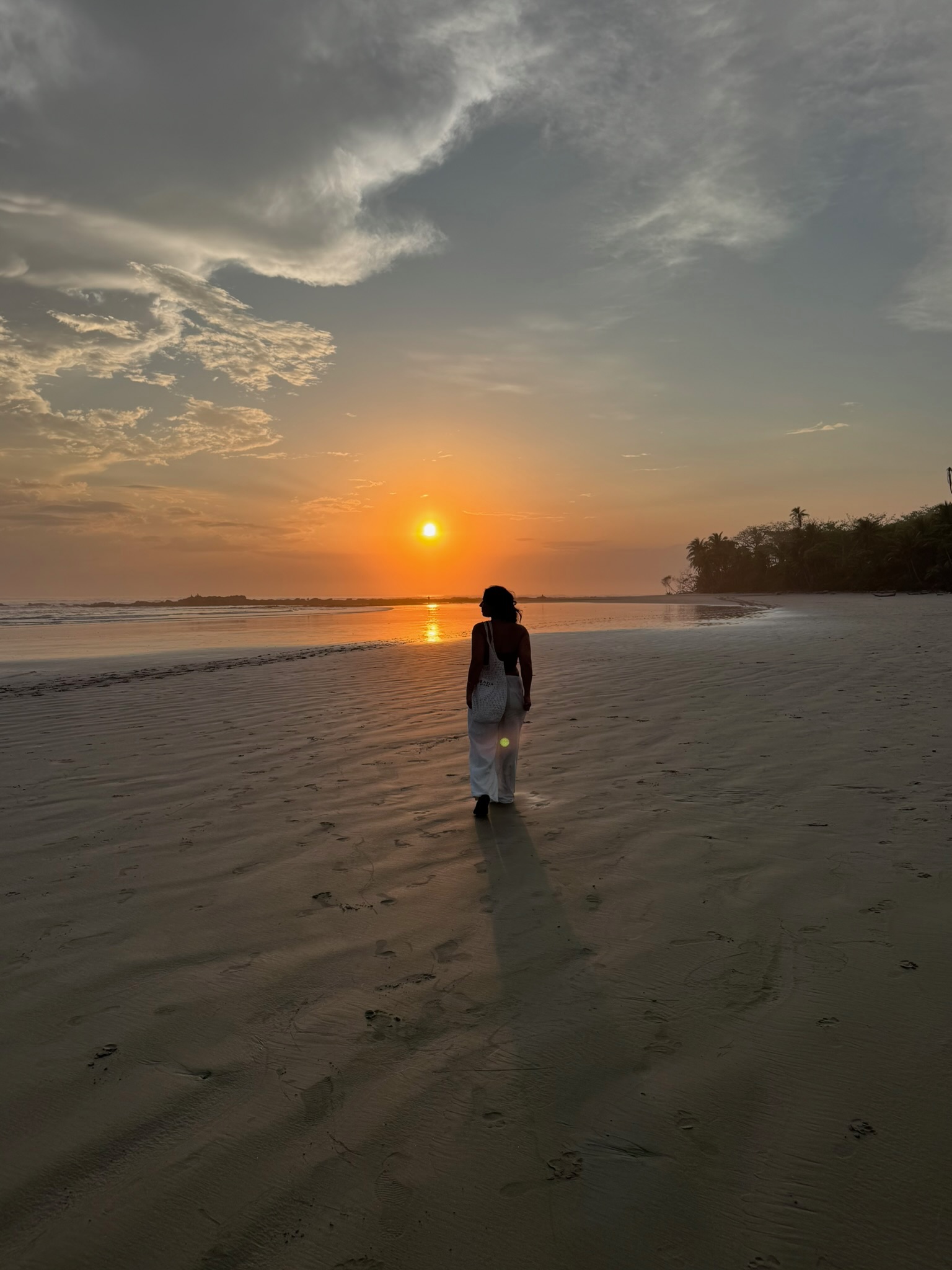 Coach Kavita walking on the beach at sunset