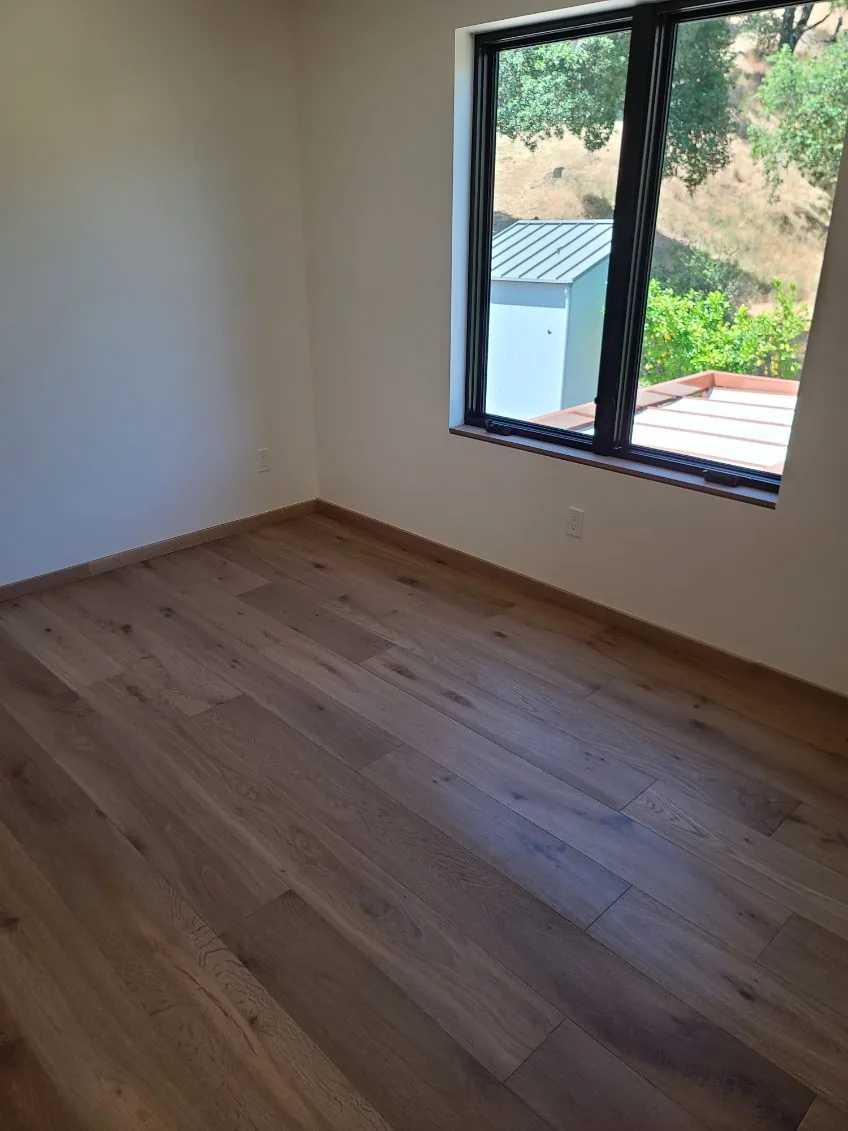 Hugo's Services — Clean room with hardwood flooring and window