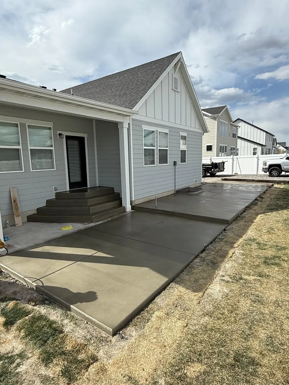 New concrete patio, walkway, and steps behind a Salt Lake County home