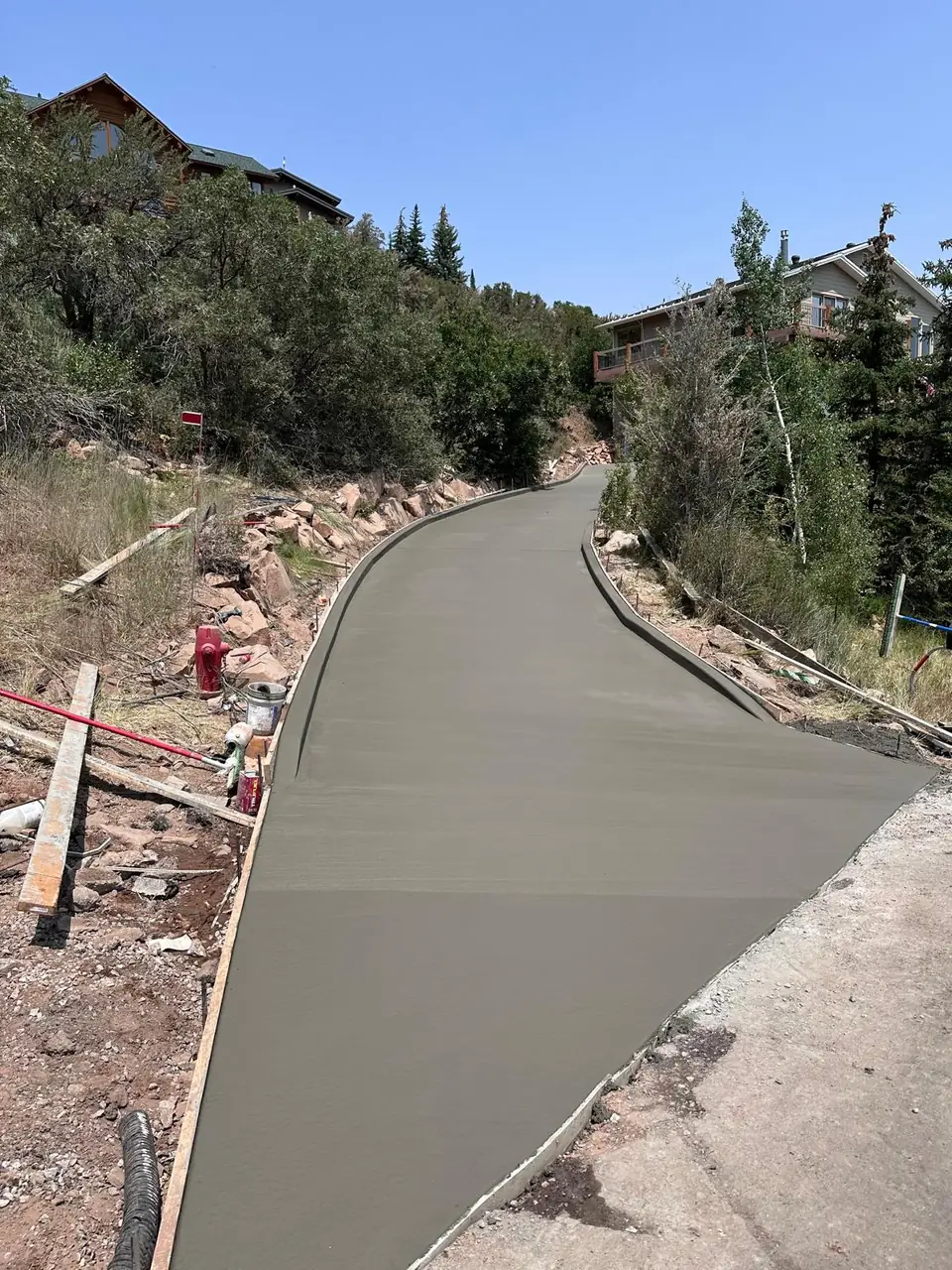 Freshly finished curved concrete driveway on a hillside property