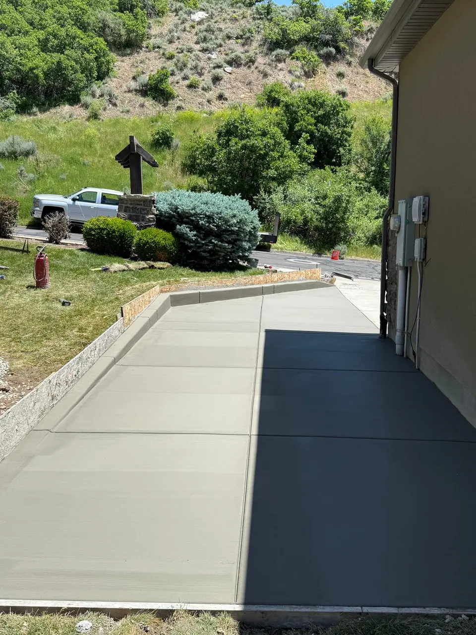 Freshly finished concrete side patio with mountain landscaping