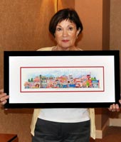 A customer smiling while holding her framed print