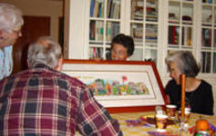 A family gathered around their framed print at the dining table