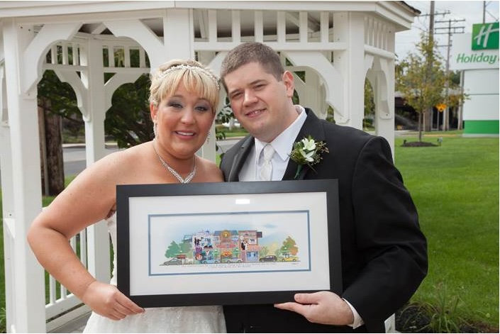 Newlyweds holding their framed Your Memory Lane wedding street print.