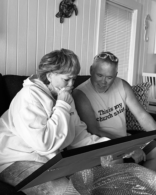 A couple looking over their framed Your Memory Lane anniversary street print.
