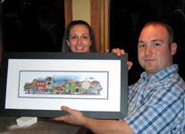 A couple holding their framed street-scene print together